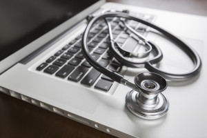 Medical Stethoscope Resting on Laptop Computer Keyboard.